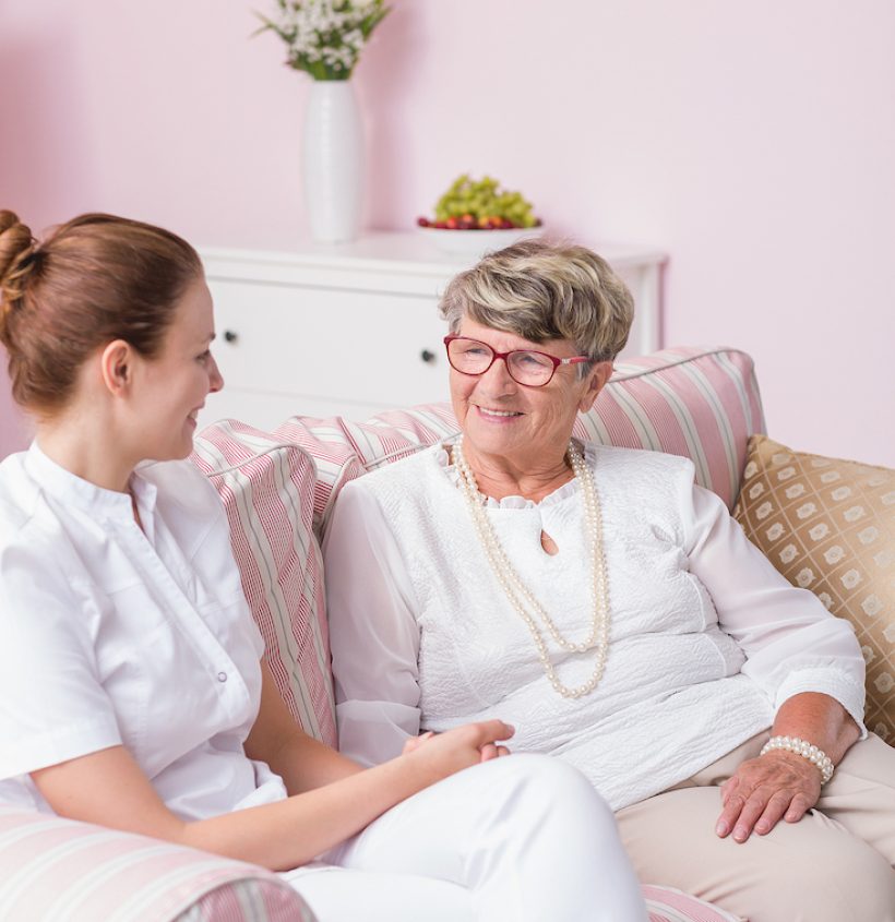Shot of a young caregiver keeping her elderly patient company in the private nursing home